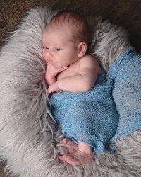 Photo of baby wrapped in blue blanket