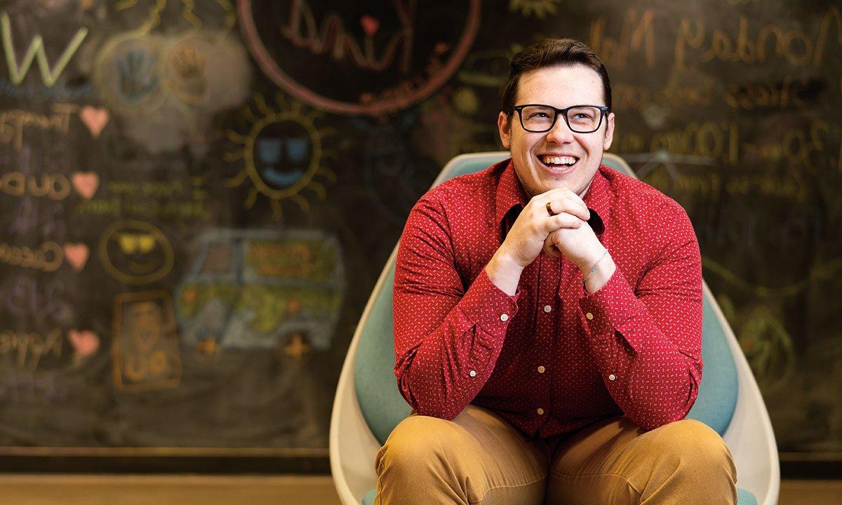 A student sitting, smiling.